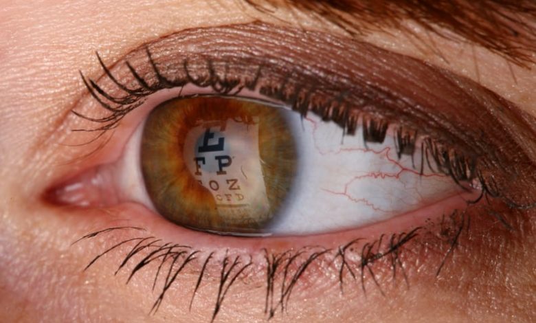 Macro shot of an Eye chart reflecting on the pupil.  Woman taking an eye exam.