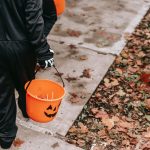 kids holding buckets of candy while trick-or-treating