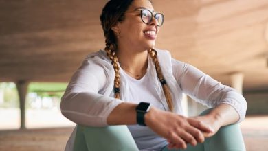 Woman in fitness clothes sitting and looking proud after accomplishing a goal through mindset training