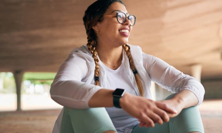 Woman in fitness clothes sitting and looking proud after accomplishing a goal through mindset training