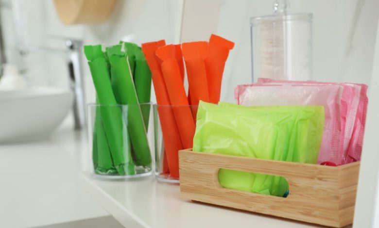 Tampons and menstrual pads on counter in bathroom. Feminine hygiene products