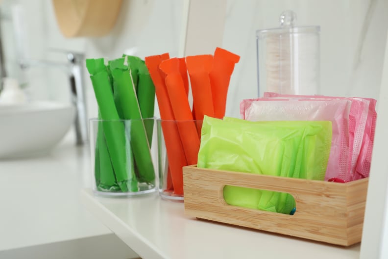 Tampons and menstrual pads on counter in bathroom. Feminine hygiene products