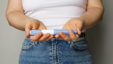 Close-up of a woman holding a blue Wegovy injection pen.