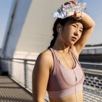 Young woman drinking water after exercising