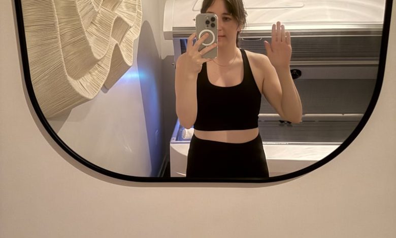 PS Health and Fitness Director Mirel Zaman waves in the mirror after a red light therapy session at Continuum Club