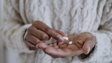 A woman's hands holding pills, contemplating when to take melatonin