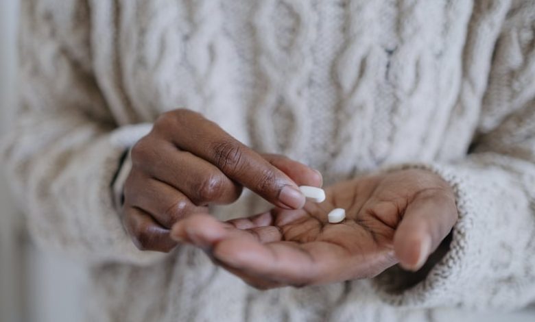 A woman's hands holding pills, contemplating when to take melatonin