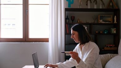 Woman looking at the computer sitting on the sofa at home searching the internet for pregnancy test instructions.