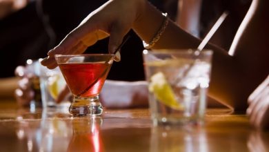 Woman with alcoholic drinks at a bar, benefits of dry January.