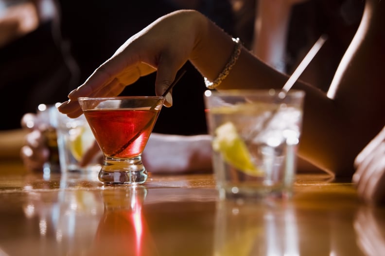 Woman with alcoholic drinks at a bar, benefits of dry January.