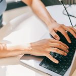 A close-up of a female using laptop. She is utilizing AI technologies like ChatGPT in her daily life.