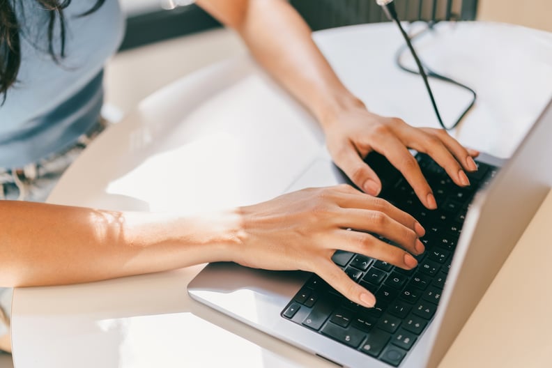 A close-up of a female using laptop. She is utilizing AI technologies like ChatGPT in her daily life.