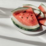 Watermelon slices on white plate on the table to represent the health benefits of watermelon